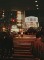 Nighttime scene in a bustling, neon-lit city.