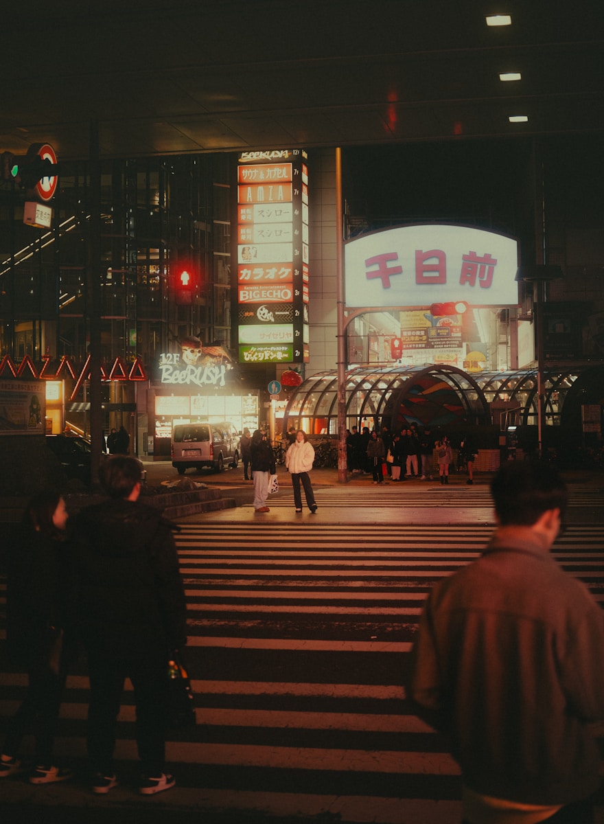 Photo by Kevin Wang Nighttime scene in a bustling, neon-lit city.